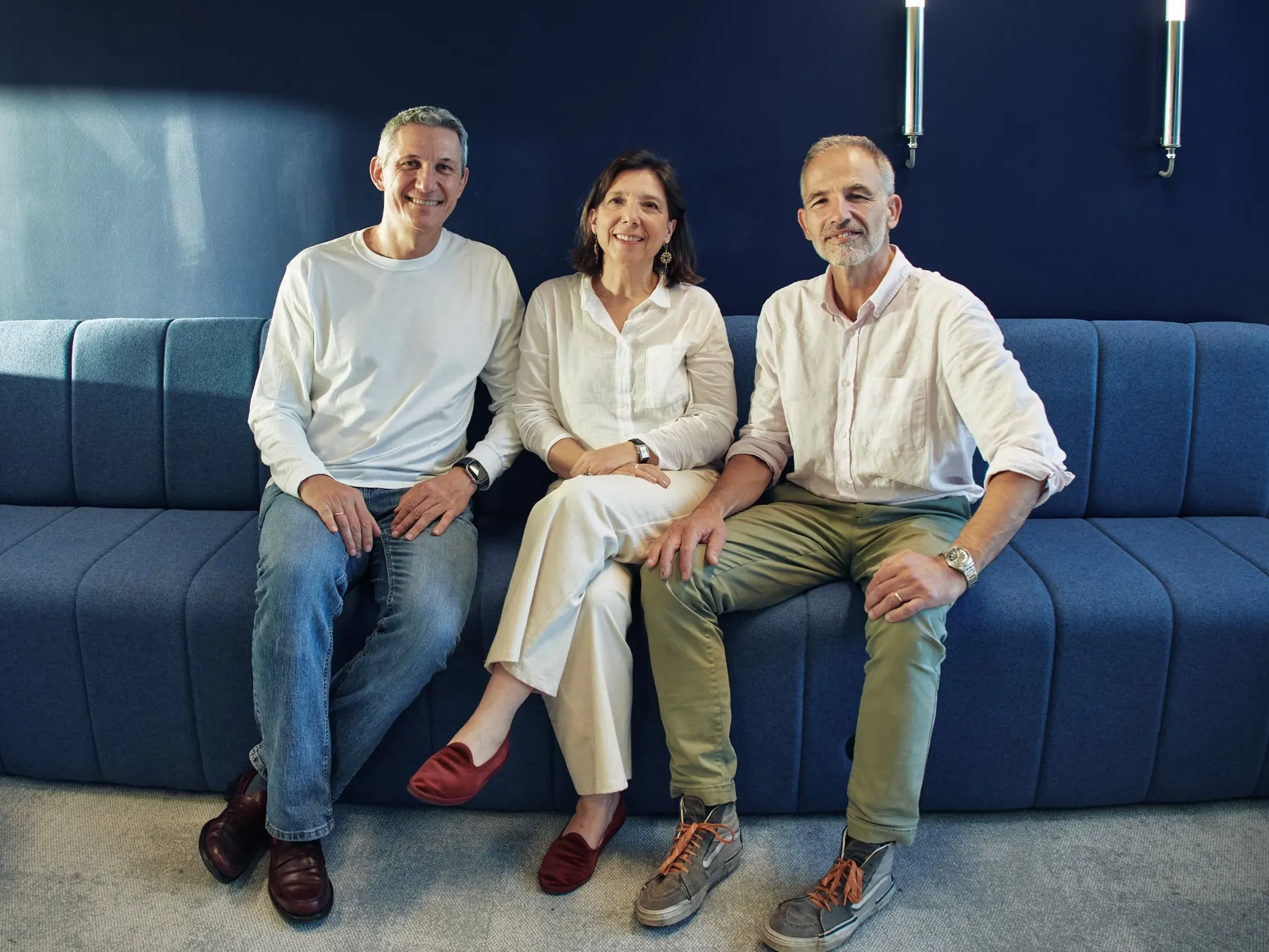Matthieu, Carole et Pierre, les trois cofondateurs d'Aphasix, assis côte à côte sur un canapé bleu.