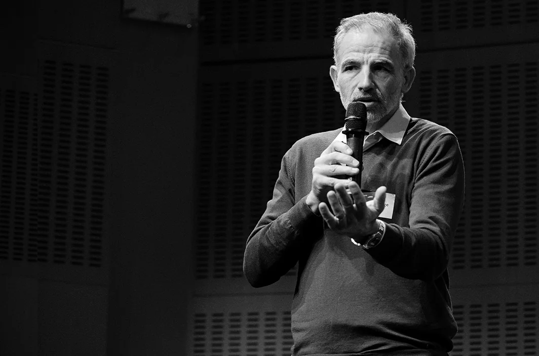 Pierre, cofondateur d'Aphasix, micro à la main sur une scène, en noir et blanc.